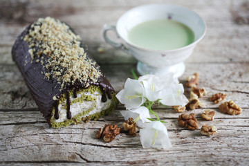 Swiss roll with matcha tea and chocolate icing filled with cream