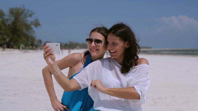 Women taking photos on the beach
