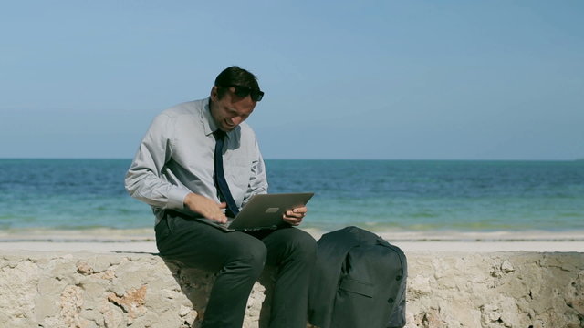 Angry businessman throwing away laptop, steadycam shot