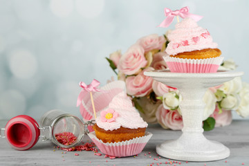 Tasty cup cakes with cream on grey wooden table