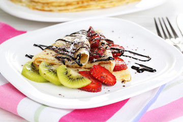 Delicious pancakes with strawberries and chocolate