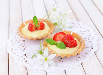 Tasty tartlets with strawberries on table close-up