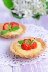 Tasty tartlets with strawberries on table close-up