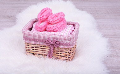 Baby clothes in basket on floor in room