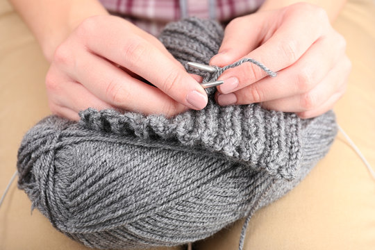 Female hands knitting with spokes close up