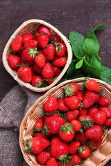 Ripe sweet strawberries in wicker basket and mint leaves
