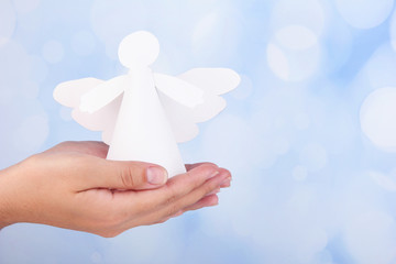 Christmas angel in hand on bright background