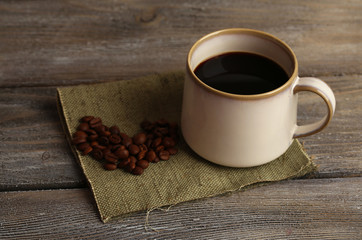 Cup with hot coffee and roasted coffee grains