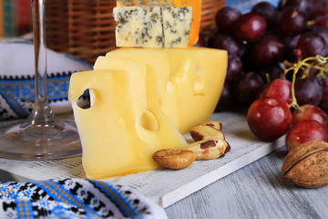 Different kinds of cheese with wine on table close-up