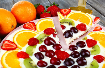 Homemade sweet pizza with fruits on wooden table, close up