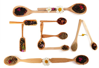 Assortment of dry tea in wooden spoons,  isolated on white