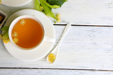 Tasty herbal tea with linden flowers on wooden table