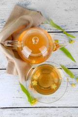 Tasty herbal tea with linden flowers on wooden table