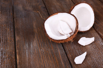 Broken coconut on wooden background
