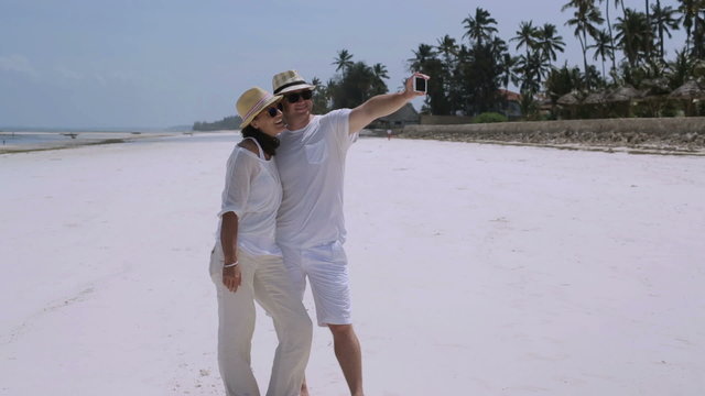 Couple taking photo on the beach