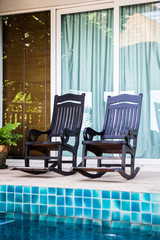 Wooden arm chairs beside the pool