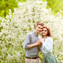 Fototapeta premium couple in love in blooming apple trees garden, smiling