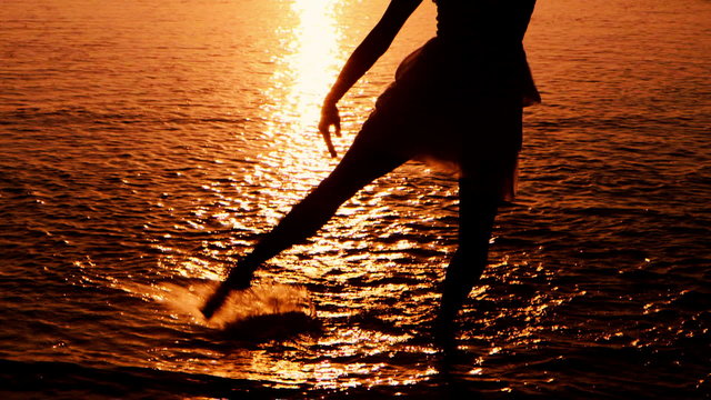 SIlhouette of girl dancing on Beach at sunset