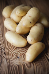 Vertical shot of freshly harvested potato over wooden surface