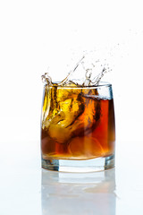 Glass of scotch whiskey and ice on a white background