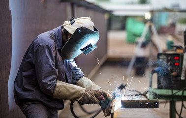 Worker with protective mask welding metal - obrazy, fototapety, plakaty