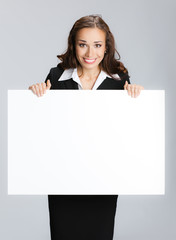 Businesswoman showing signboard, over grey