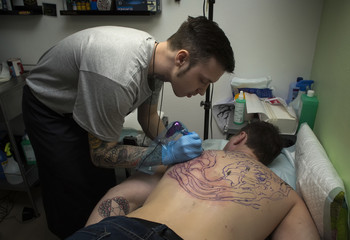 Tattooer does a tattoo