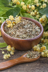 linden tea in a wooden bowl and scoop surrounded by flowers