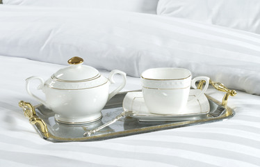 tray with cup and sugar bowl on a bed