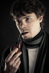 intelligent man with a pipe in a mouth isolated on black
