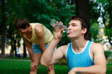 Young sportsman drinking water at the park
