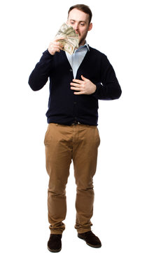 Young man contemplating a handful of cash