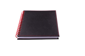 A black notebook with a red ring binder over white background
