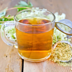 Herbal tea from meadowsweet dry in mug with strainer