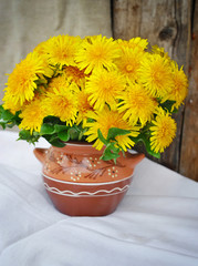 Bouquet of dandelions in a ceramic jug