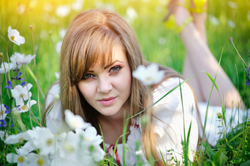 Beautiful young woman on the meadow with white flowers