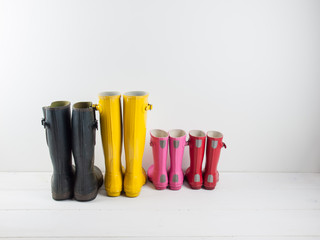 rubber boots against a white wall