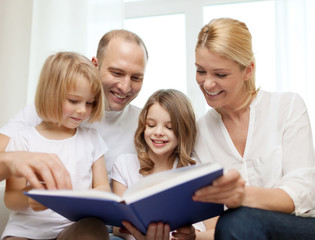 smiling family and two little girls with book
