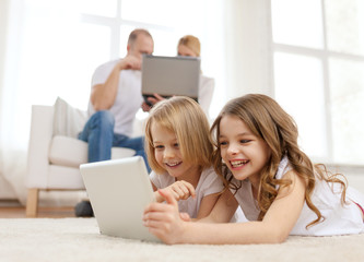 smiling sister with tablet pc and parents on back