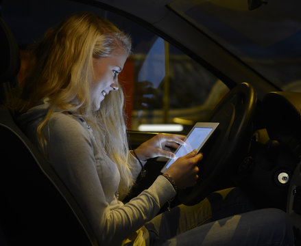 Frau mit tablet computer im Auto