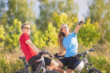 Fototapeta premium Mountain Bikers Standing and Resting in Forest Surroundings in