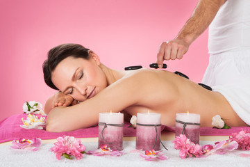 Obraz na płótnie Canvas Woman Receiving Hot Stone Therapy In Spa