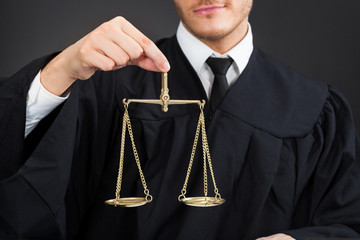Male Judge Holding Weight Scale