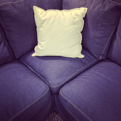 Blue textile sofa with white cushion