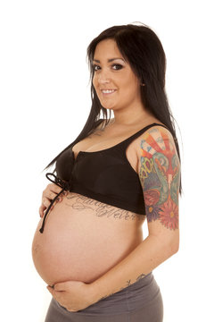 pregnant woman tattoos show belly look smile