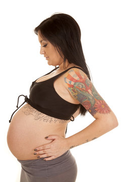 pregnant woman tattoos show belly side look down