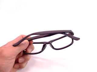 折り畳んだメガネを持つ手