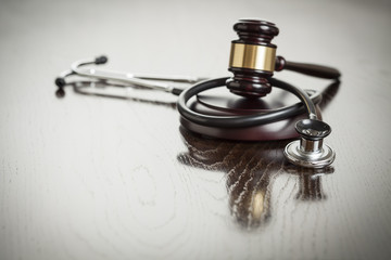 Gavel and Stethoscope on Reflective Table