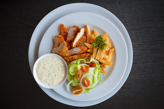 Chicken strips and fries combo on black wood