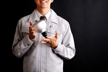 電球を持っている作業服の男性